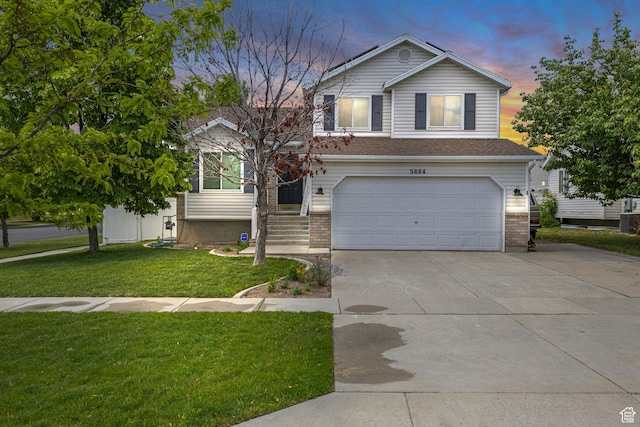 5884 S Impressions Dr W, Salt Lake City, UT 84118 - view of front facade featuring an attached garage, driveway, and a lawn