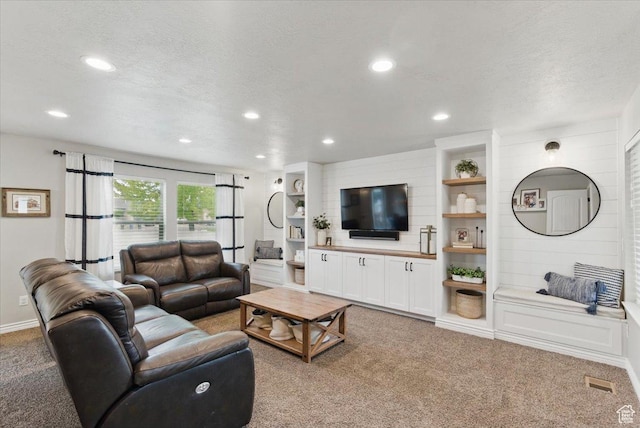 living area with light colored carpet, recessed lighting, and a textured ceiling