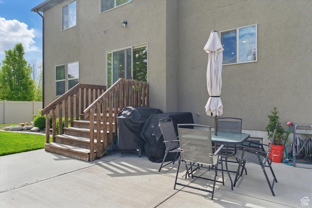 view of patio featuring grilling area, fence, and outdoor dining area