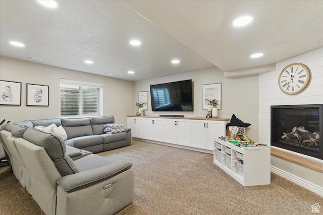 living area with light colored carpet, recessed lighting, and a large fireplace