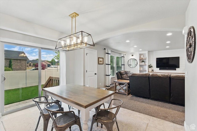 dining area with light carpet, recessed lighting, light tile patterned flooring, a chandelier, and arched walkways