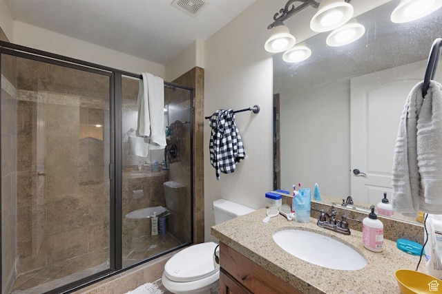 full bath featuring toilet, a stall shower, and vanity