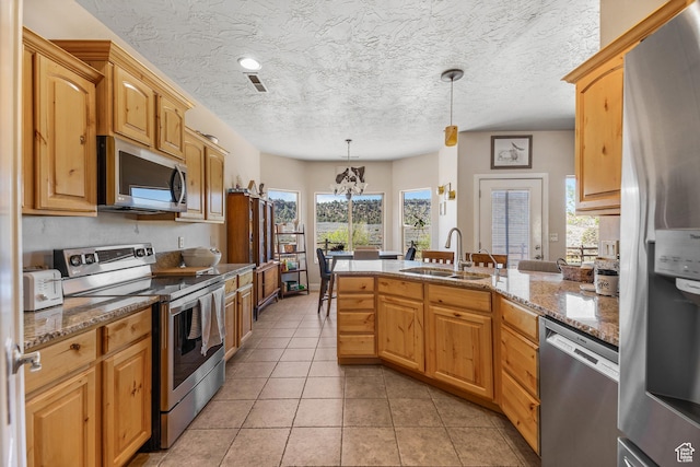 881 W Smithsonian Way, Apple Valley, UT 84737 - kitchen featuring stainless steel appliances, a sink, a peninsula, healthy amount of natural light, and a textured ceiling