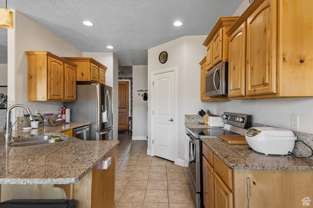 881 W Smithsonian Way, Apple Valley, UT 84737 - kitchen with stainless steel appliances, a sink, stone countertops, a peninsula, and brown cabinets