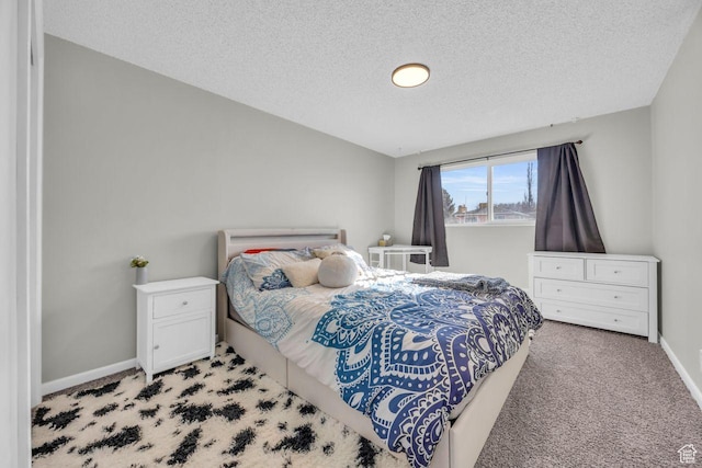 bedroom featuring carpet, a textured ceiling, and baseboards
