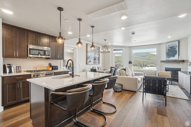 909 W Peace Tree Trl Unit 513, Kamas, UT 84036 - kitchen with stainless steel microwave, a sink, open floor plan, hardwood / wood-style floors, and recessed lighting