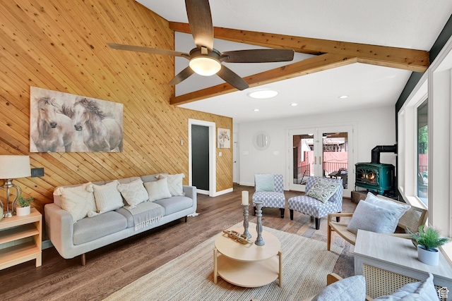 3348 E Stonehill Ln, Cottonwood Heights, UT 84121 - living room with a wood stove, beam ceiling, wood finished floors, ceiling fan, and wooden walls