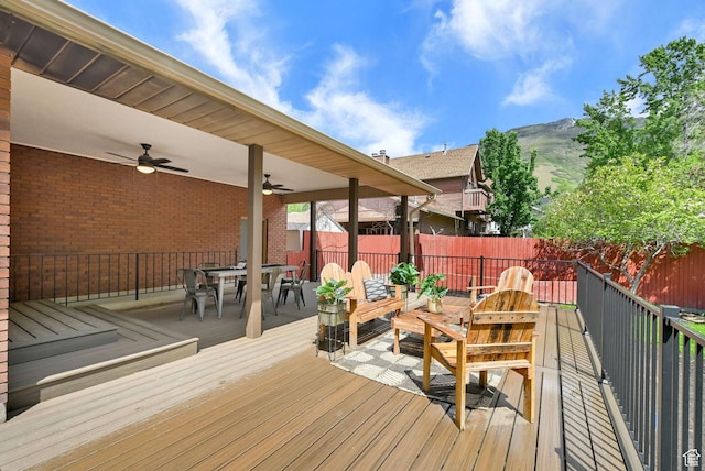 3348 E Stonehill Ln, Cottonwood Heights, UT 84121 - wooden terrace with outdoor dining space, a ceiling fan, a fenced backyard, and a mountain view