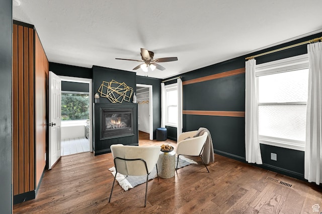 3348 E Stonehill Ln, Cottonwood Heights, UT 84121 - living area with a glass covered fireplace, wood finished floors, a ceiling fan, and baseboards
