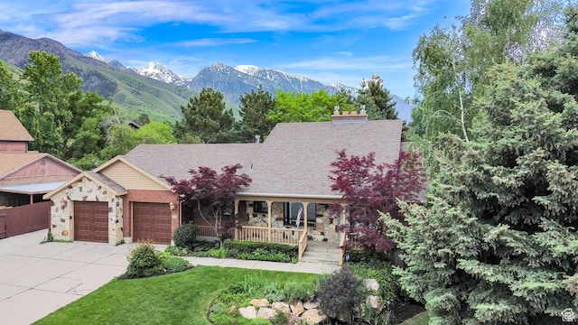 3348 E Stonehill Ln, Cottonwood Heights, UT 84121 - view of front of property with stone siding, an attached garage, a mountain view, driveway, and a porch