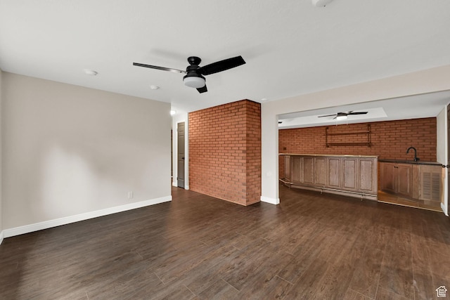 3348 E Stonehill Ln, Cottonwood Heights, UT 84121 - unfurnished living room featuring ceiling fan, brick wall, dark wood-type flooring, baseboards, and a sink