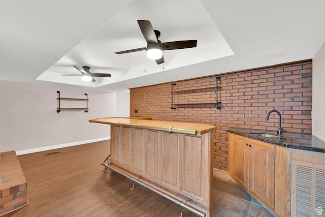 3348 E Stonehill Ln, Cottonwood Heights, UT 84121 - indoor wet bar with brick wall, a raised ceiling, ceiling fan, baseboards, and dark wood-style flooring