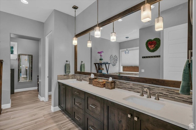 1865 N Park Grove Dr, Washington, UT 84780 - bathroom with baseboards, decorative backsplash, double vanity, wood finished floors, and recessed lighting