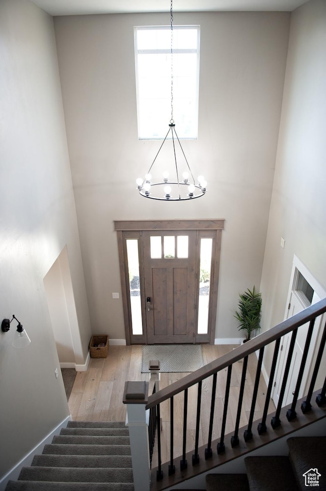 224 S Dry Creek Ln W, Vineyard, UT 84058 - entrance foyer featuring a towering ceiling, stairs, a chandelier, wood finished floors, and healthy amount of natural light