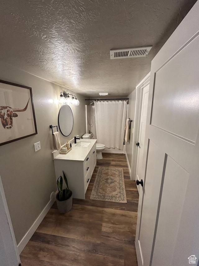 224 S Dry Creek Ln W, Vineyard, UT 84058 - bathroom featuring wood finished floors, toilet, a textured ceiling, vanity, and curtained shower