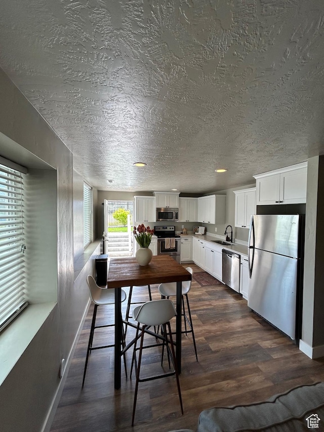 224 S Dry Creek Ln W, Vineyard, UT 84058 - dining space with dark wood-type flooring, baseboards, and a textured ceiling