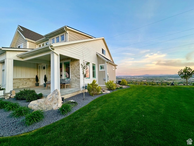 191 E 3475 N, North Ogden, UT 84414 - view of home's exterior with a yard, stone siding, covered porch, and board and batten siding