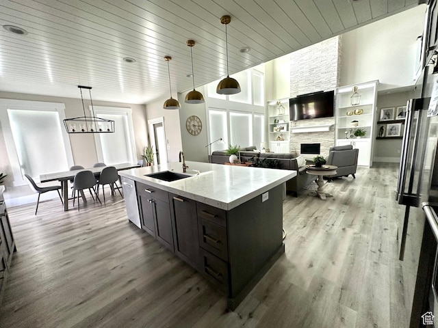 191 E 3475 N, North Ogden, UT 84414 - kitchen featuring a sink, a stone fireplace, dishwasher, light wood-type flooring, and decorative light fixtures
