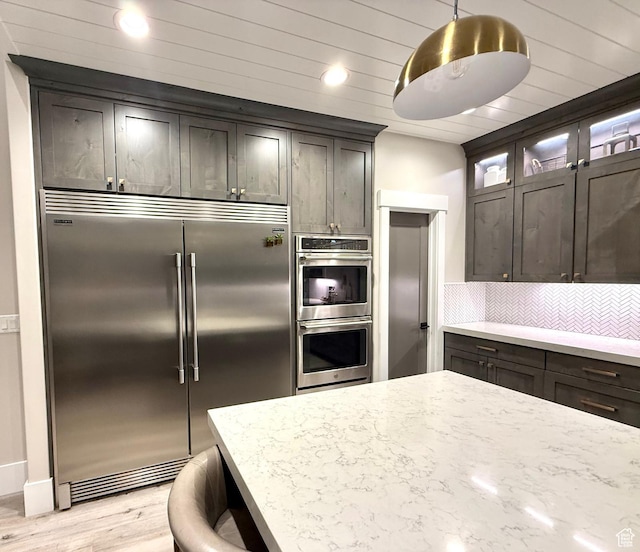 191 E 3475 N, North Ogden, UT 84414 - kitchen with appliances with stainless steel finishes, light wood-type flooring, backsplash, light stone countertops, and glass insert cabinets
