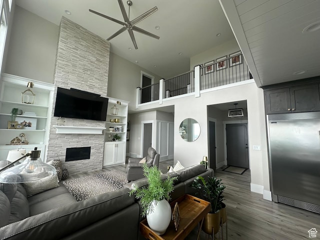191 E 3475 N, North Ogden, UT 84414 - living area with a high ceiling, ceiling fan, a fireplace, wood finished floors, and baseboards