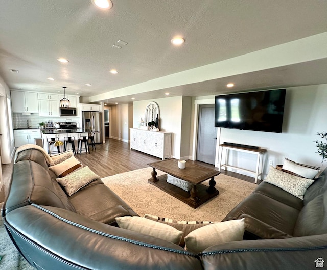 191 E 3475 N, North Ogden, UT 84414 - living area with wood finished floors, recessed lighting, baseboards, and a textured ceiling