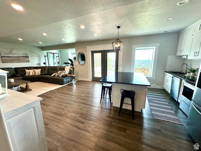 191 E 3475 N, North Ogden, UT 84414 - living area featuring a textured ceiling, baseboards, dark wood-style flooring, recessed lighting, and french doors