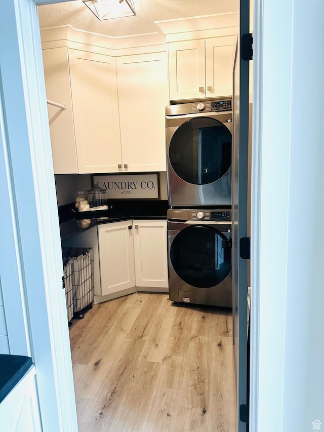 191 E 3475 N, North Ogden, UT 84414 - laundry room featuring estacked washer and dryer, cabinet space, and light wood-style floors