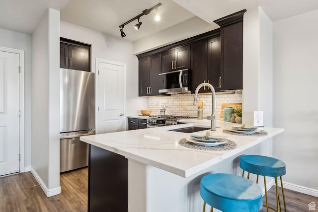 5 S 500 W Unit 506, Salt Lake City, UT 84101 - kitchen with stainless steel appliances, backsplash, a sink, dark brown cabinetry, and dark wood-style floors