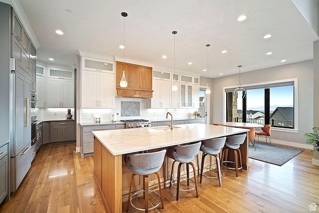 3196 E 25 S, Layton, UT 84040 - kitchen featuring gray cabinetry, a sink, light wood-type flooring, a center island with sink, and wall oven