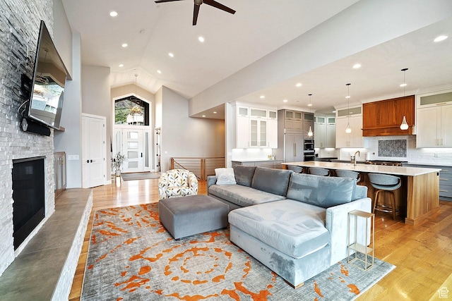 3196 E 25 S, Layton, UT 84040 - living room featuring a ceiling fan, light wood finished floors, a fireplace, recessed lighting, and high vaulted ceiling