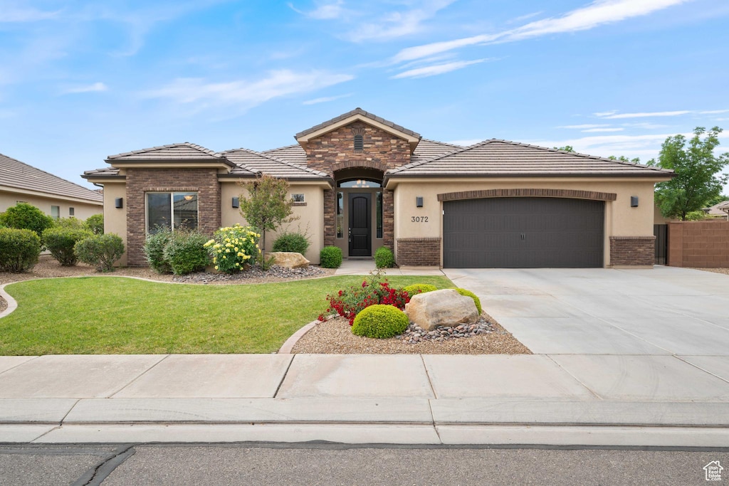 3072 E Amaranth Dr, St George, UT 84790 - view of front of home with stucco siding, an attached garage, driveway, and a tiled roof
