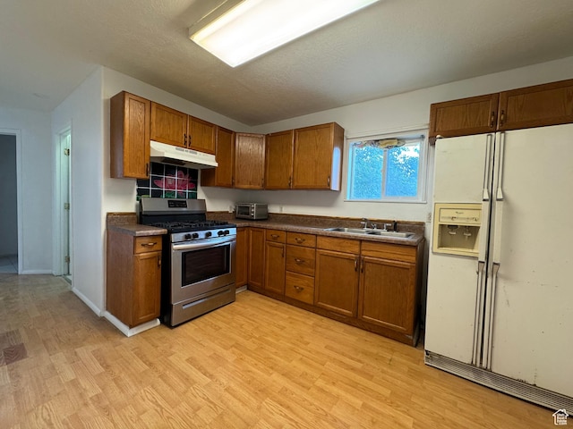1666 W Warnock St S, Salt Lake City, UT 84119 - kitchen with white fridge with ice dispenser, stainless steel range with gas stovetop, under cabinet range hood, brown cabinetry, and a sink