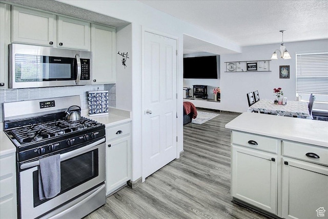 178 W Heidelberg Pl N, Stansbury Park, UT 84074 - kitchen featuring stainless steel appliances, a chandelier, light countertops, light wood-style floors, and a textured ceiling