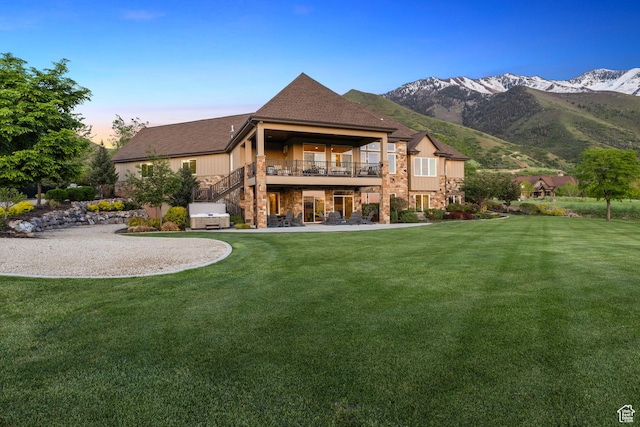 1515 E Maple St, Mapleton, UT 84664 - back of property at dusk featuring a yard, stone siding, a mountain view, and a patio