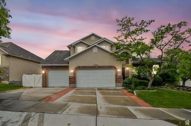 14438 Rose Summit Dr, Herriman, UT 84096 - traditional home featuring driveway, an attached garage, brick siding, stucco siding, and a gate