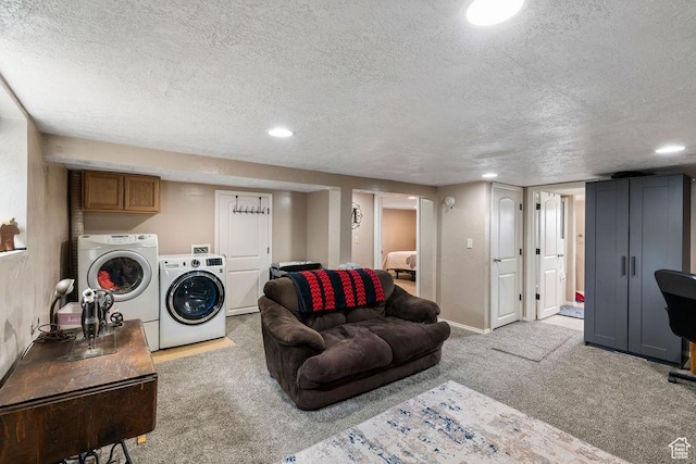 living area featuring washer and clothes dryer, light colored carpet, a textured ceiling, recessed lighting, and baseboards