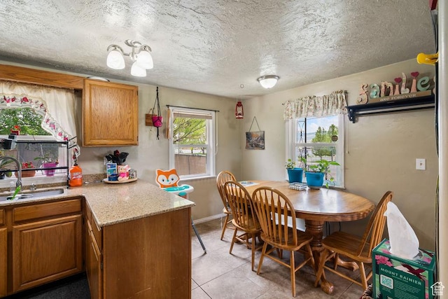 dining area with light tile patterned floors, a textured ceiling, and baseboards