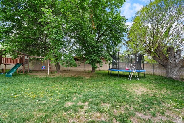view of yard featuring a trampoline and a playground