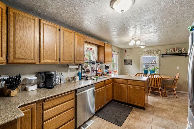 kitchen featuring dishwasher, a sink, light countertops, a peninsula, and light tile patterned floors