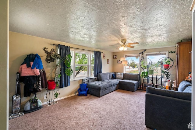 carpeted living area with a ceiling fan, baseboards, and a textured ceiling