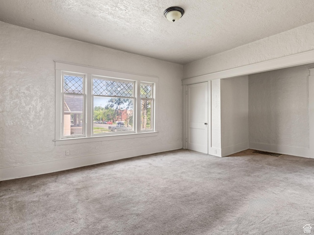 551 E 27th St, Ogden, UT 84403 - unfurnished bedroom featuring carpet flooring, a textured ceiling, a closet, a textured wall, and baseboards