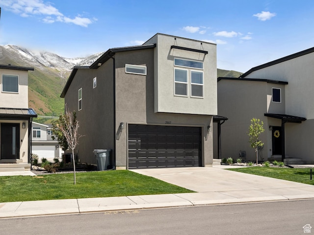 3957 S White Ash Dr, Mapleton, UT 84664 - contemporary house featuring an attached garage, a mountain view, concrete driveway, a front yard, and stucco siding