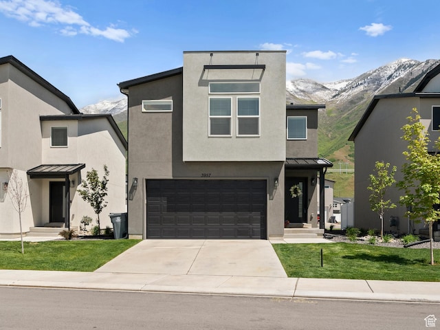 3957 S White Ash Dr, Mapleton, UT 84664 - contemporary home featuring a standing seam roof, driveway, a garage, a front lawn, and stucco siding