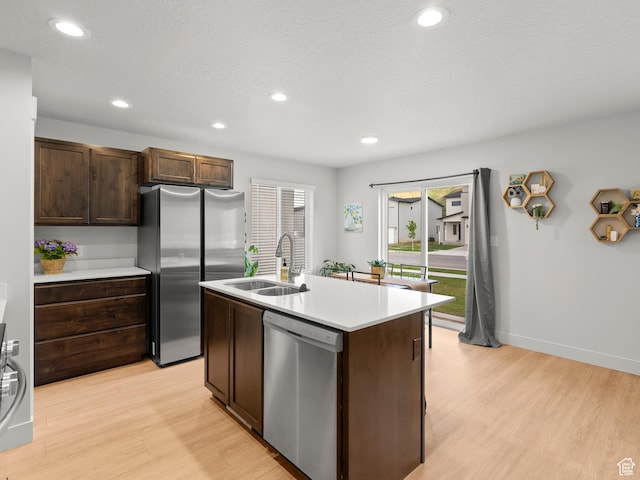 3957 S White Ash Dr, Mapleton, UT 84664 - kitchen featuring appliances with stainless steel finishes, a sink, light wood-style flooring, dark brown cabinets, and recessed lighting