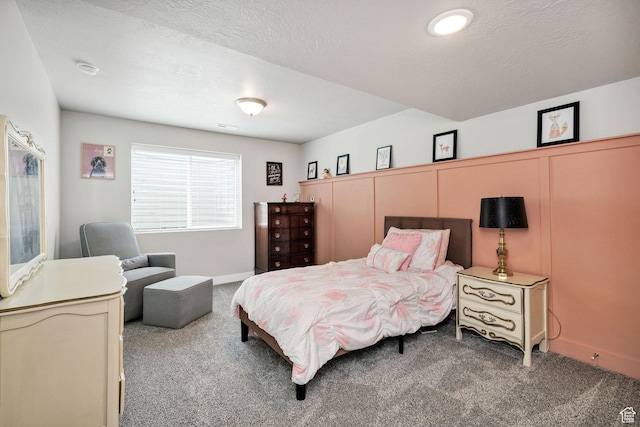 bedroom featuring carpet floors, baseboards, and a textured ceiling
