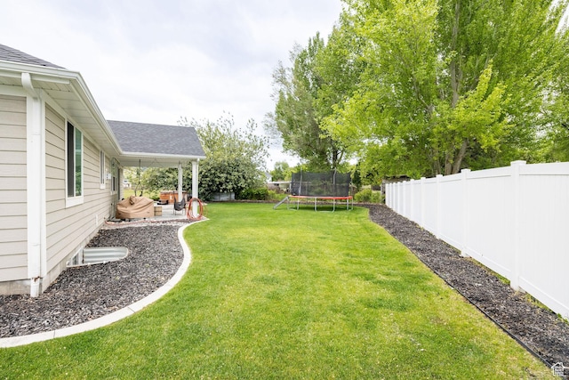 view of yard featuring a trampoline and a patio area