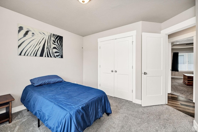 bedroom with baseboards, carpet floors, and a closet
