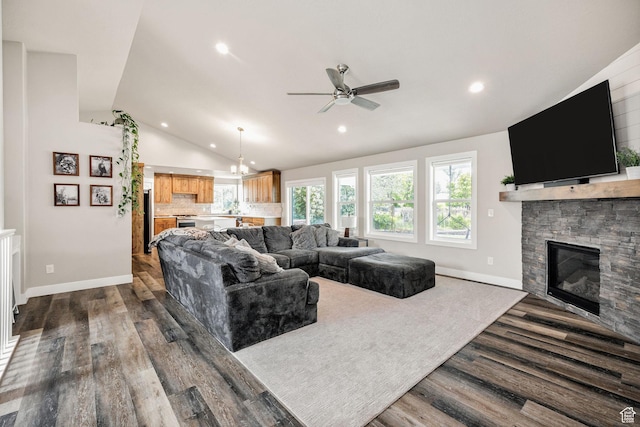 living room with lofted ceiling, a fireplace, dark wood-type flooring, a ceiling fan, and recessed lighting