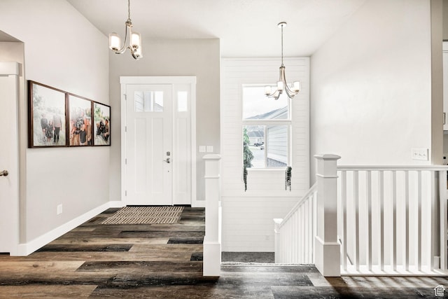 entrance foyer featuring a chandelier, healthy amount of natural light, and wood finished floors