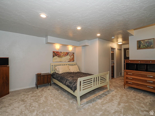 carpeted bedroom with a textured ceiling, recessed lighting, and baseboards